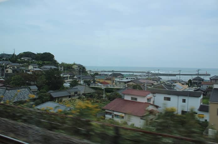 車窓からみる住宅街と海